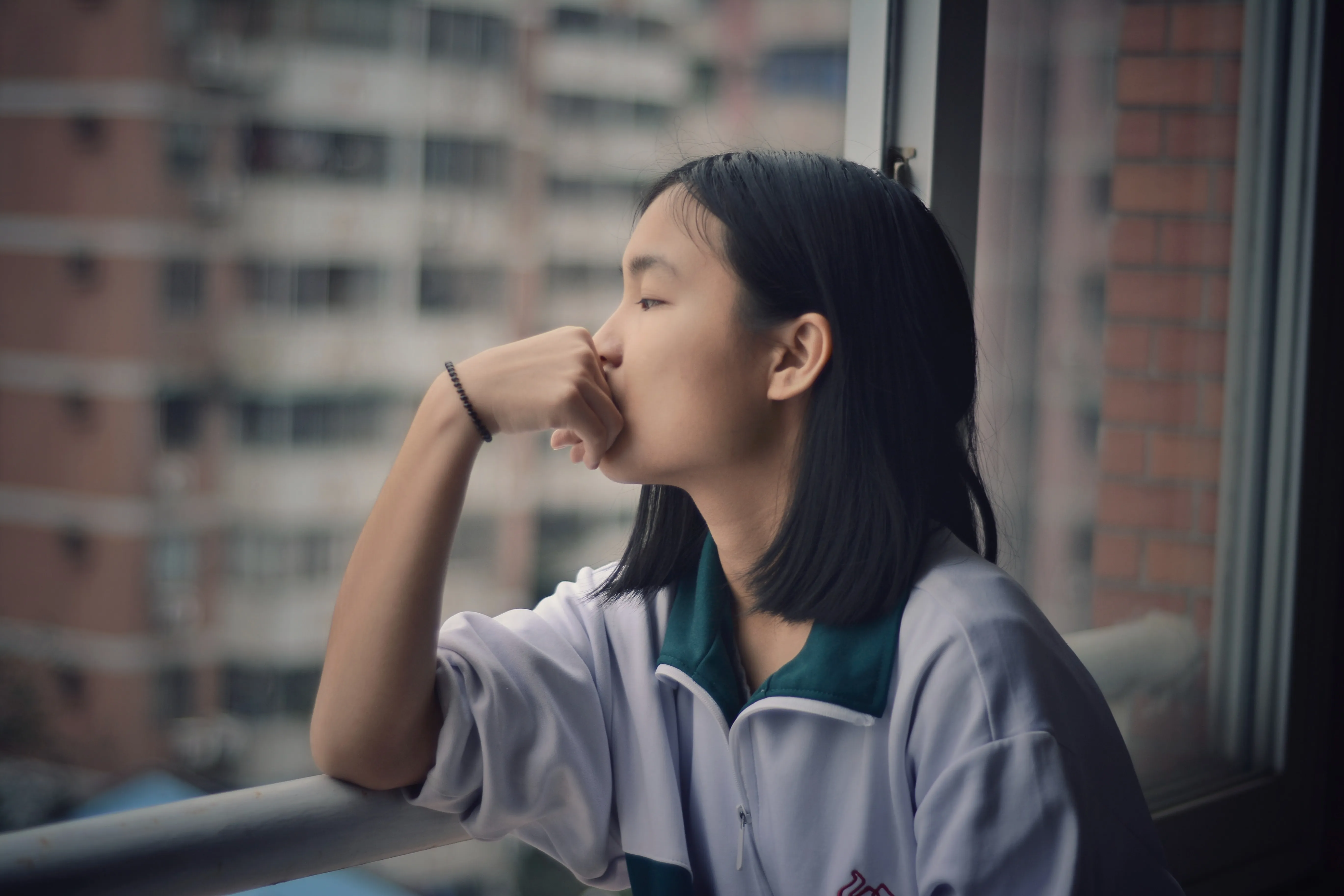 Woman sitting at a window thinking.